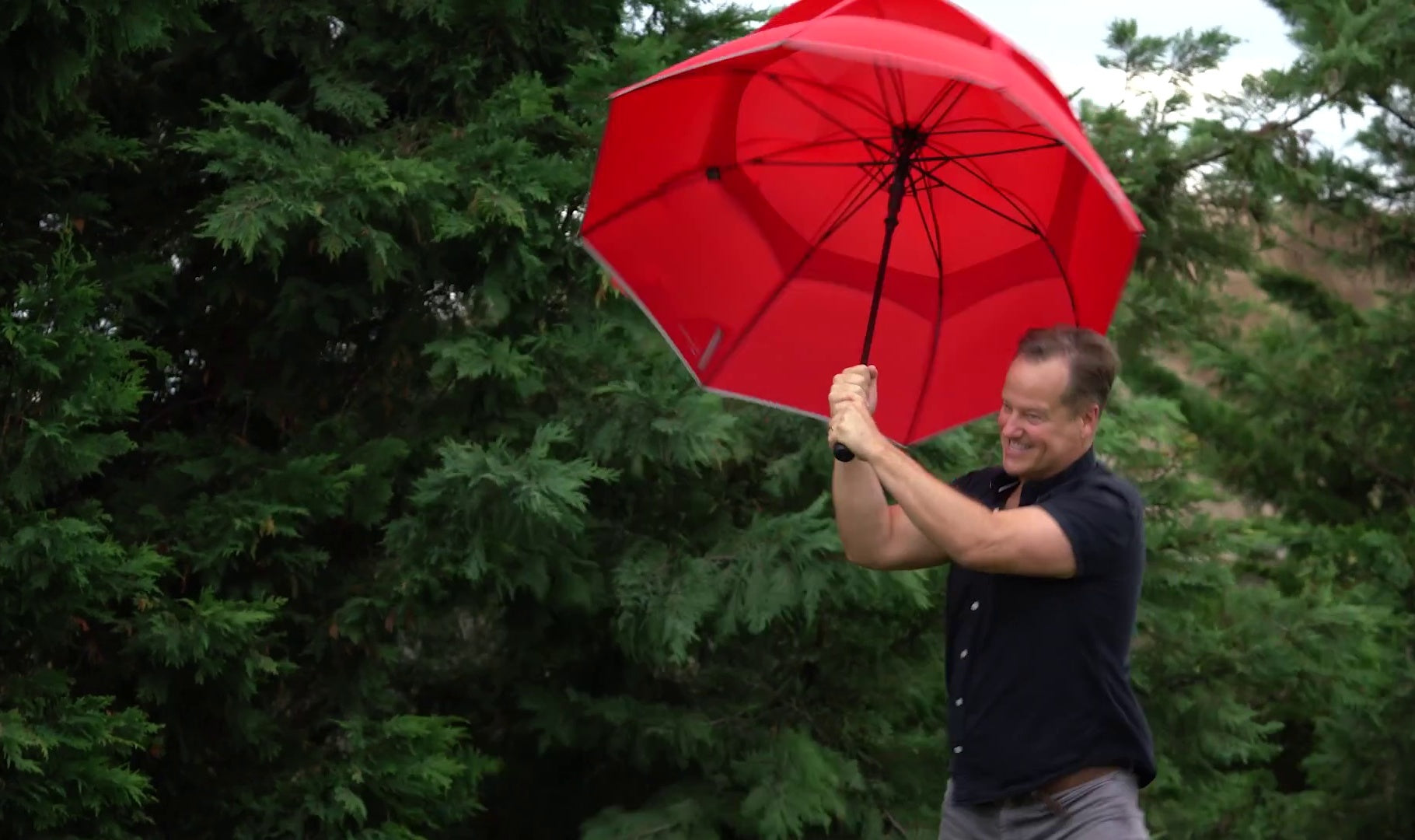 Rick Reichmuth, meteorologist and founder of Weatherman, testing an umbrella outdoors