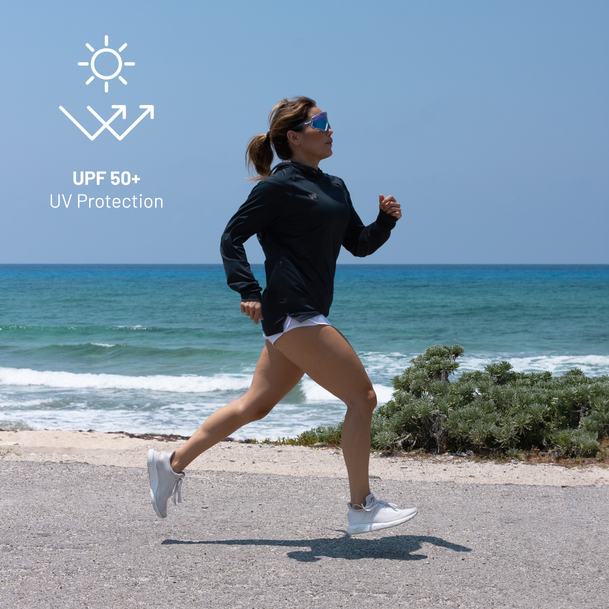 Woman running near beach wearing Weatherman UPF 50+ UV Protection Sun Shirt in midnight blue.